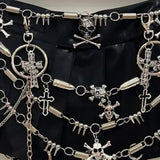Minifalda plisada con apliques de calavera y anilla de cadena metálica 