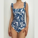 Traje de baño de una pieza con volantes y estampado abstracto en contraste con falda de playa 
