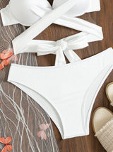 Traje de baño de tres piezas con tirantes finos, malla con apliques de mariposa, lazo en contraste y parte delantera cruzada 