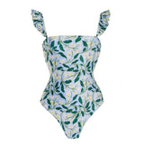 Traje de baño de una pieza con volantes y estampado abstracto en contraste con falda de playa 